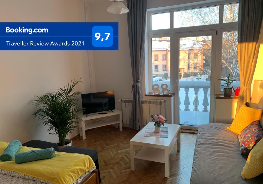 a living room with a couch and a table at White Apartment House in Bielsko-Biała