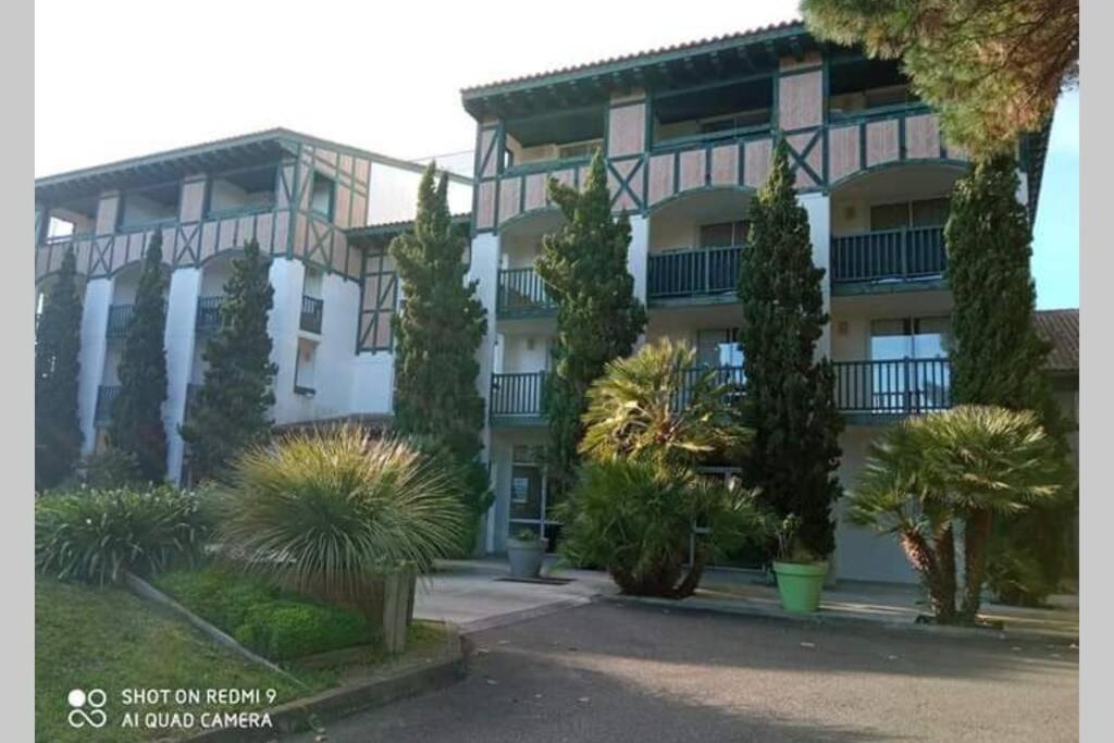 un edificio con muchos árboles delante de él en Studio lumineux idéalement situé (golf et plage)., en Moliets-et-Maa