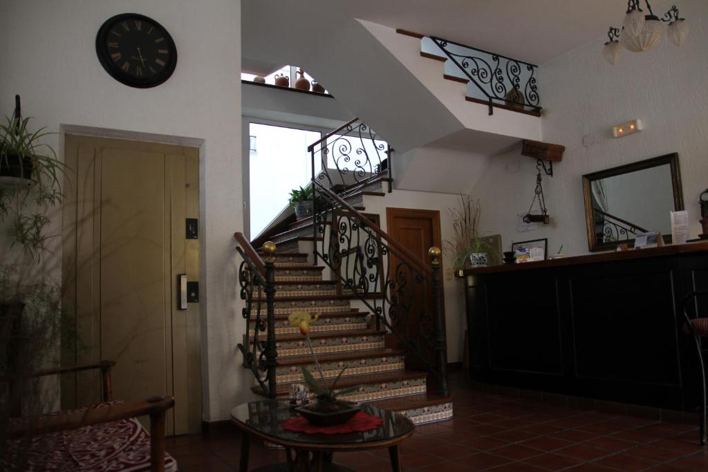 a staircase in a room with a clock on the wall at Hostal Goya II in Carbonero el Mayor