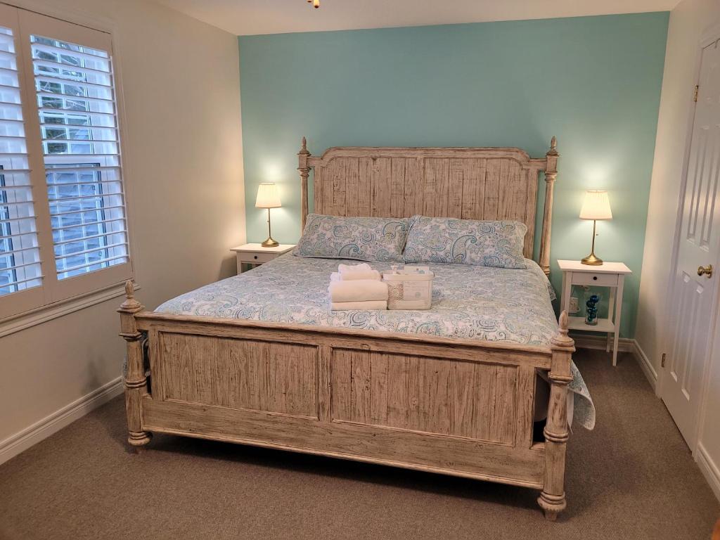 a bedroom with a large wooden bed with two lamps at La Maison de Sophie in Niagara on the Lake