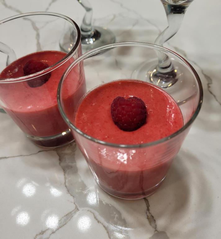 two glasses of red liquid with a raspberry in it at La Maison de Sophie in Niagara-on-the-Lake