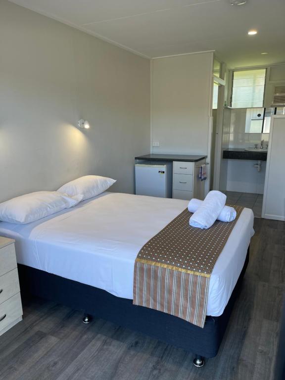 a bedroom with a large bed with towels on it at Queens Beach Hotel in Bowen