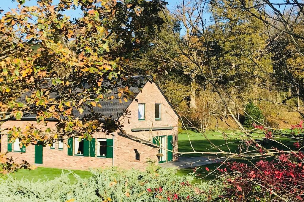 una gran casa de ladrillo con persianas verdes y árboles en Lovely Meadow House in the land of Croix Scaille, en Gedinne