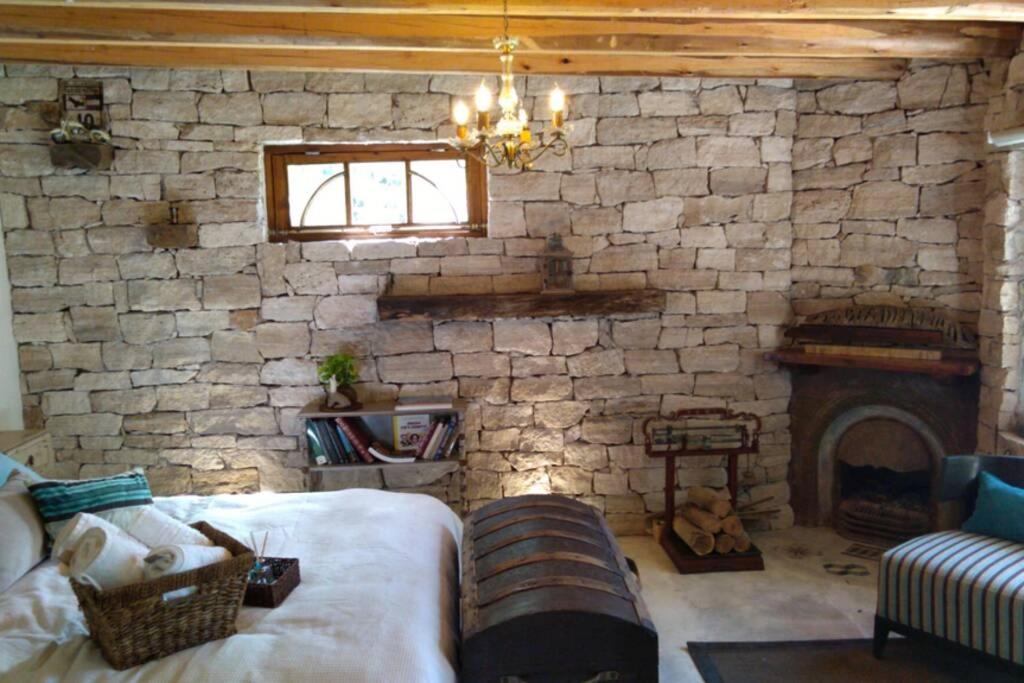 a living room with a stone fireplace and a couch at Aromos de Olivares in Chacras de Coria
