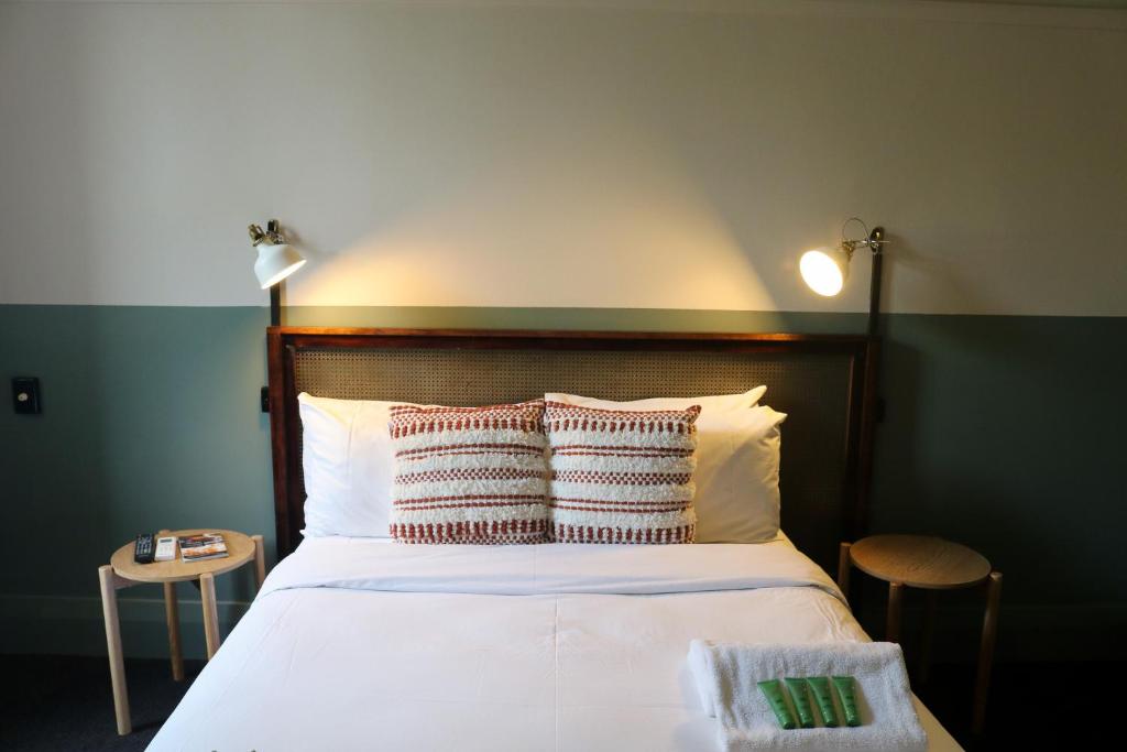 a bedroom with a large white bed with two pillows at Darlo Bar Darlinghurst in Sydney