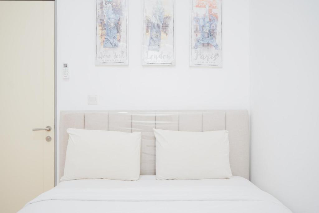 a white bed with two pillows in a bedroom at Great Choice 2BR Apartment at M-Town Residence By Travelio in Tangerang