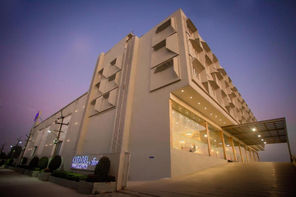 a white building with a sign on the side of it at Citadel Hotel By Vinnca in Hyderabad