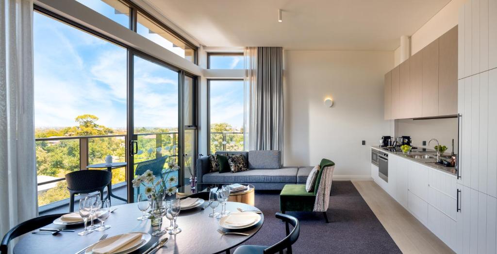 una cucina e un soggiorno con tavolo e sedie di Majestic M Suites a Adelaide