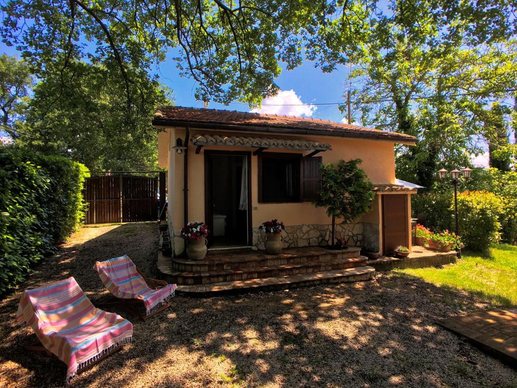 una piccola casa con due sedie nel cortile di Tranquil holiday home in Selci with swimming pool a Selci