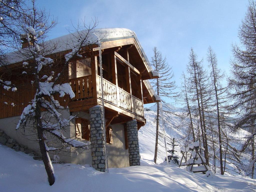 een houten hut in de sneeuw met sneeuw bedekte bomen bij Charming chalet with view on Mont Blanc in Peisey-Nancroix