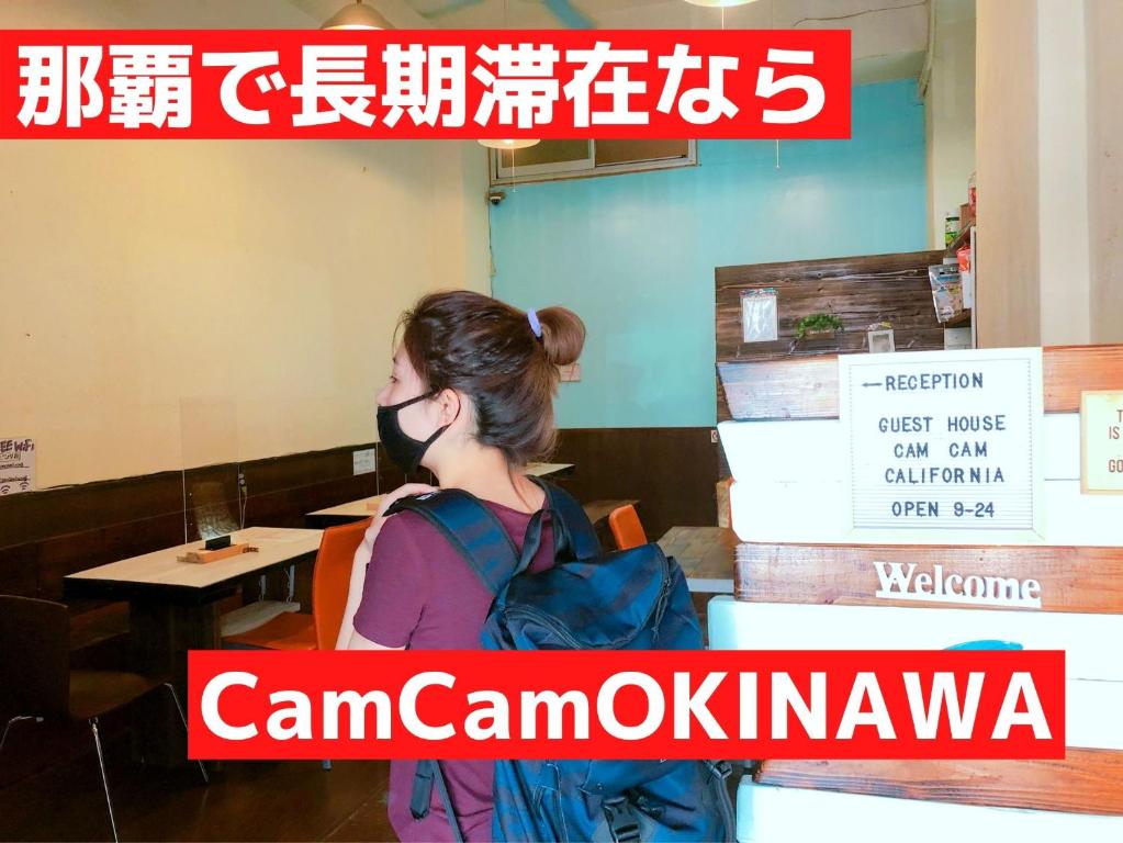 a woman wearing a gas mask in a restaurant at Guest House Cam Cam Okinawa in Naha