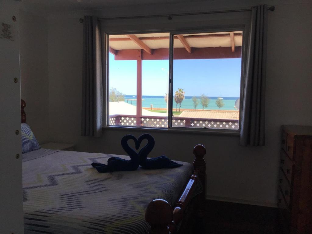a bedroom with a bed with a window with a heart on it at Best Beach Villa in Denham
