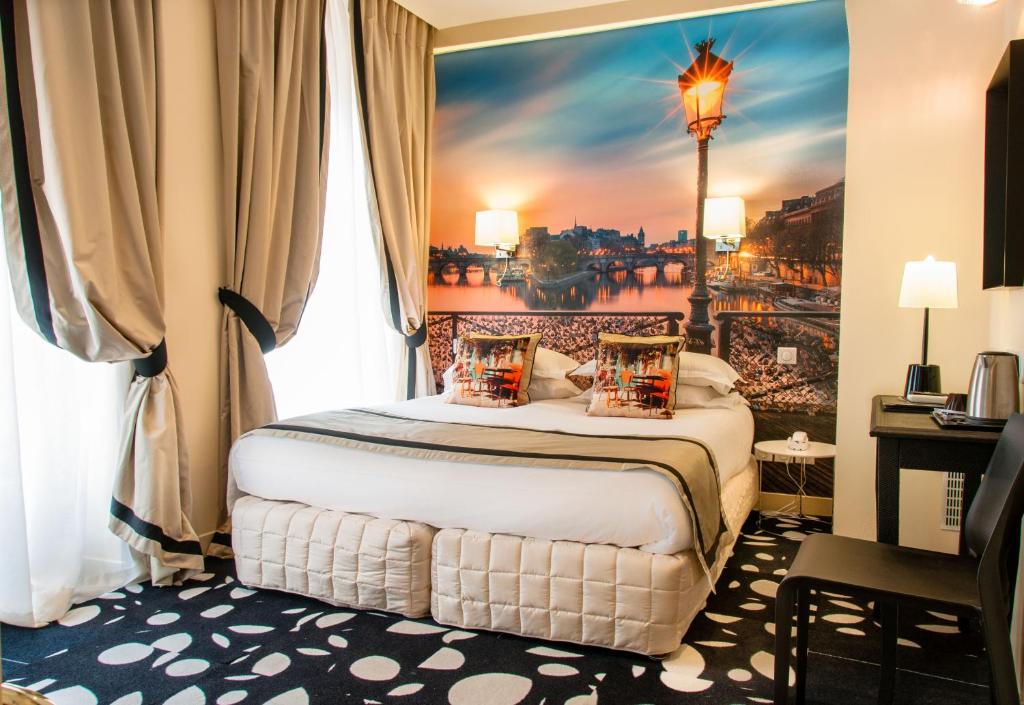 a hotel room with a bed with a painting on the wall at Hotel Ile de France Opéra in Paris