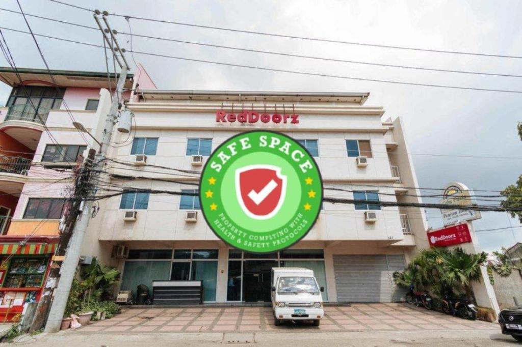 a car parked in front of a building with a sign at RedDoorz @ Bonifacio St Cebu in Cebu City