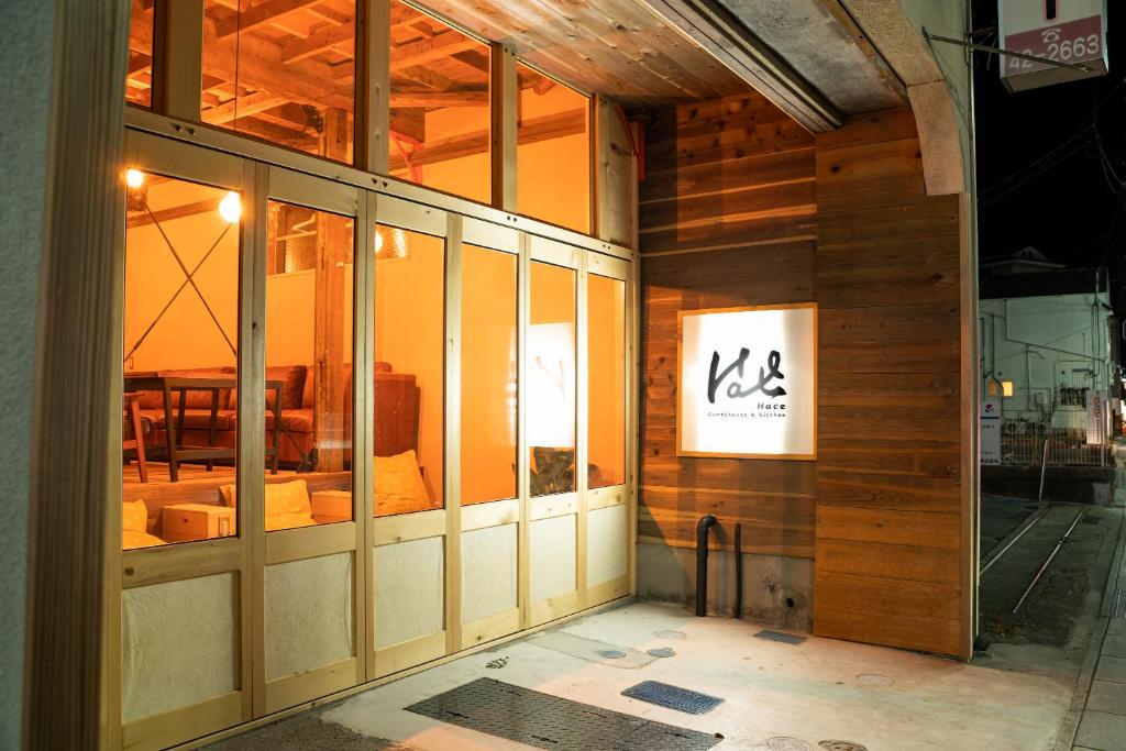 un edificio con un cartel en el costado en Guesthouse & Kitchen Hace en Iwaki