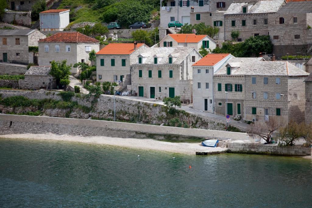 eine Gruppe von Gebäuden neben einem Wasserkörper in der Unterkunft House Tea in Pučišća