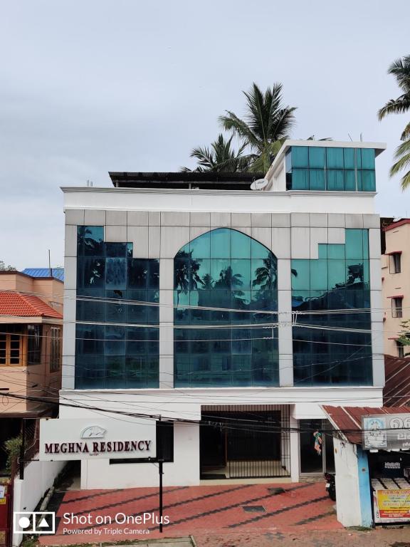un edificio con muchas ventanas en una calle en MEGHNA RESIDENCY en Thiruvananthapuram
