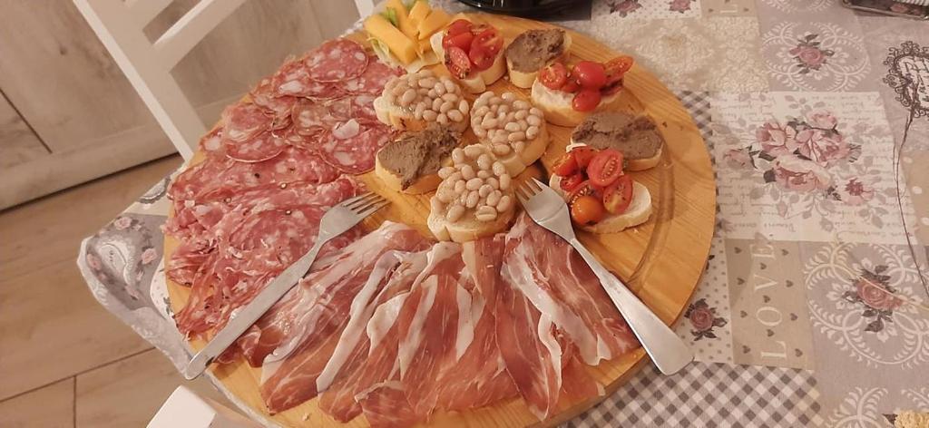 フィレンツェにあるB & B Eliana e Ristoranteのテーブル上の肉野菜のまな板