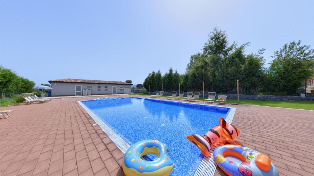 a swimming pool with two inflatables sitting next to it at Agriturismo dell'Etna in Riposto