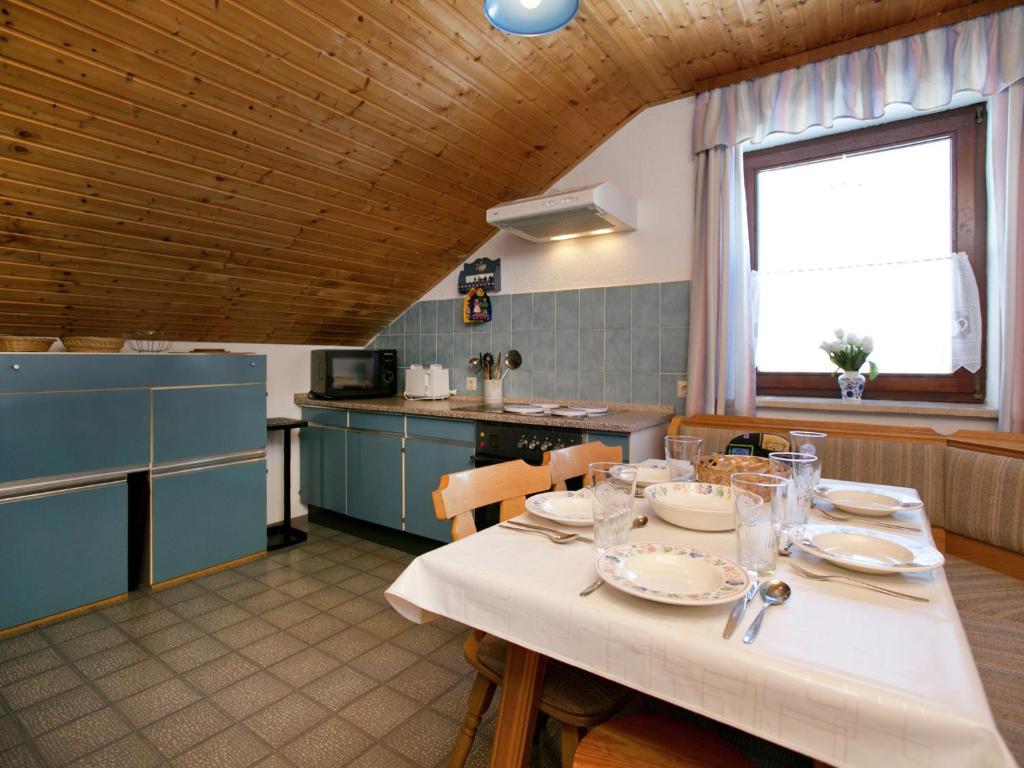 eine Küche mit einem Tisch mit Tellern und Gläsern darauf in der Unterkunft Restful Holiday Home near Ski Lift in Petersthal in Oy-Mittelberg