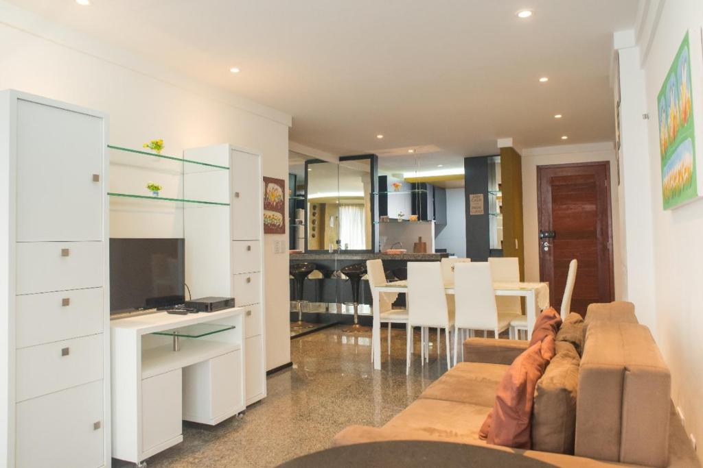 a living room with a couch and a dining room at Flat Natal - Localização TOP e WIFI in Natal