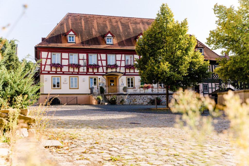 a large house with a red and white building at Hotel Goldner Stern in Königsberg in Bayern