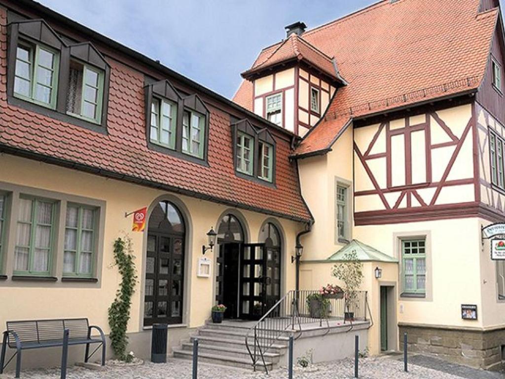 um edifício com um banco à frente em Herrenschenke-Café Eiring em Königsberg in Bayern