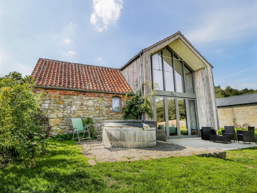 an old stone house with a tub in the yard at Finest Retreats - Oak House in Tealby