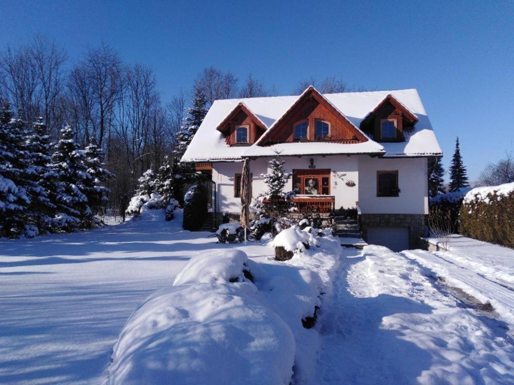 una casa con nieve en el suelo delante de ella en Privát U čápů v Beskydech, en Pržno