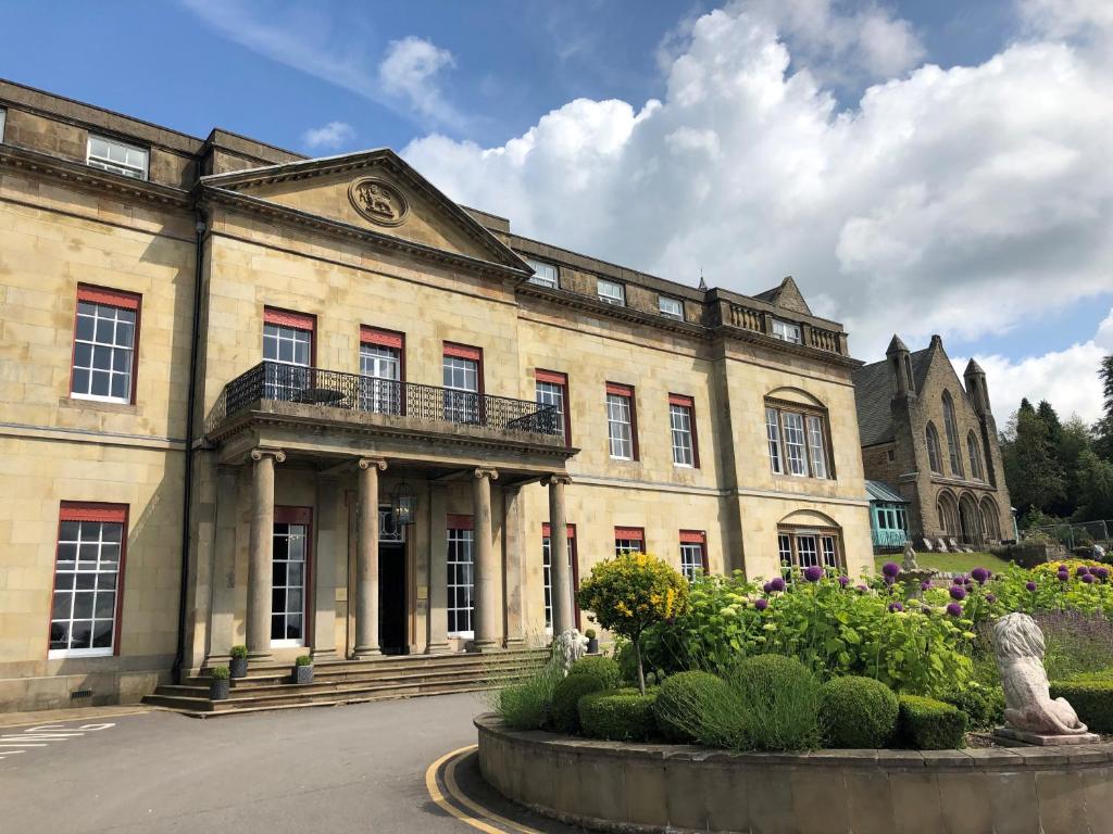 a large building with a clock on the front of it at Shrigley Hall Hotel in Macclesfield