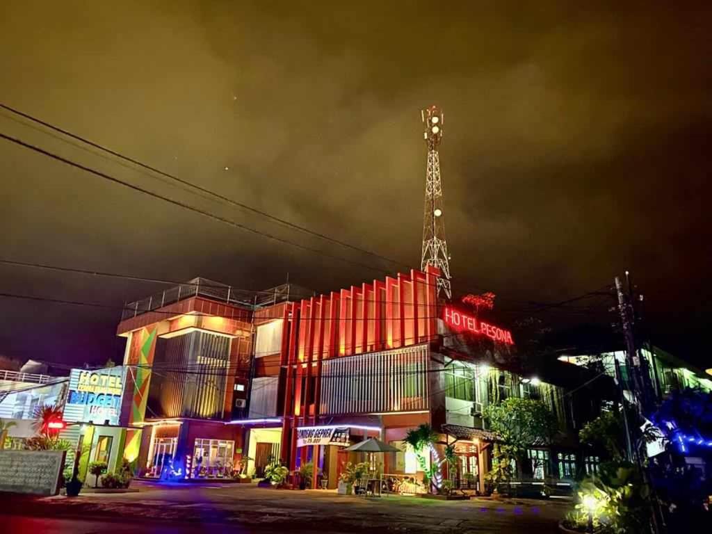 un bâtiment avec une tour en haut le soir dans l'établissement Hotel Pesona Merak, à Merak