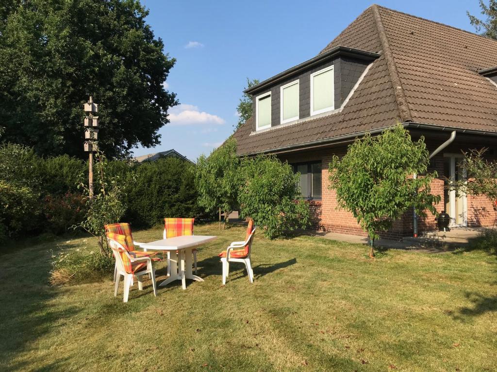 a table and chairs in the yard of a house at Ferienwohnung Mühlenweg in Süderlügum