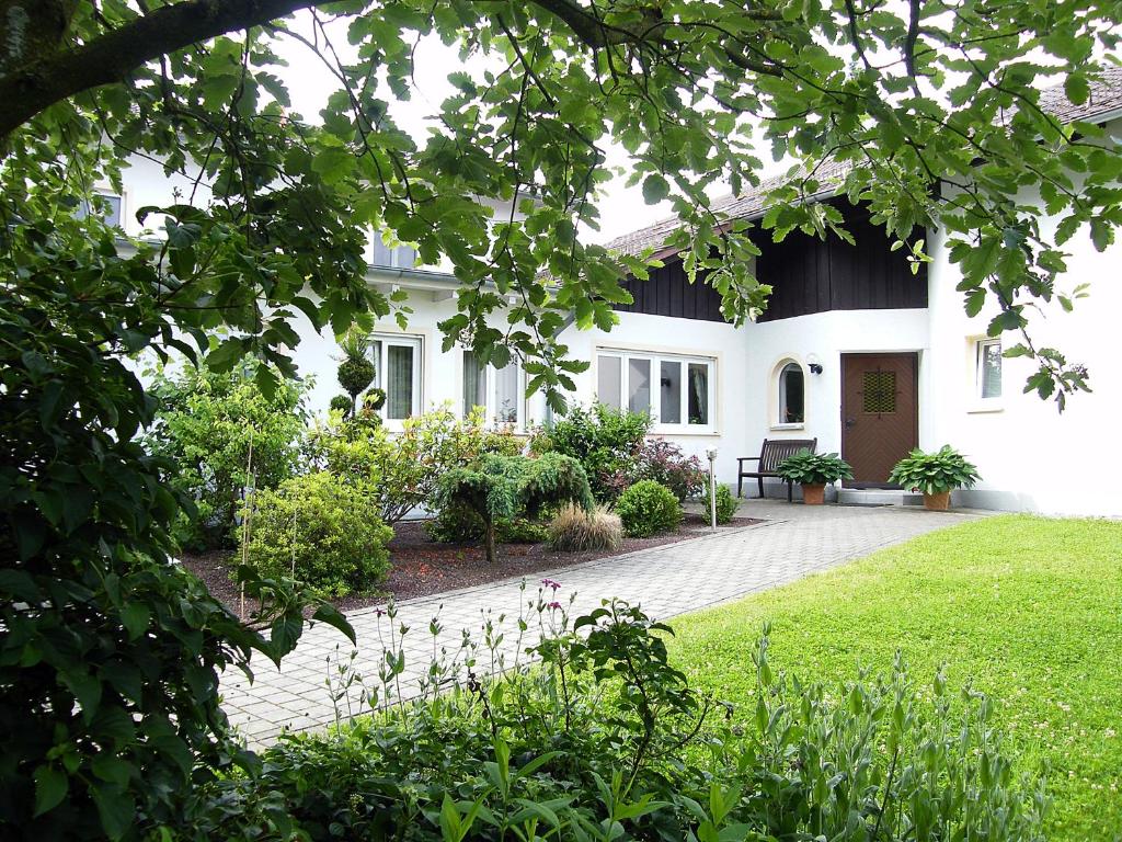 una casa blanca con un jardín delante de ella en Landhaus Oberrainer, en Bad Griesbach