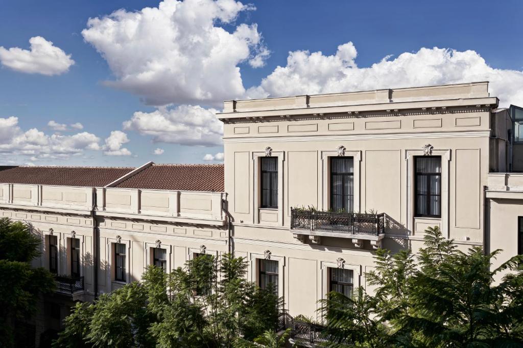 a white building with a balcony on top of it at NLH MONASTIRAKI - Neighborhood Lifestyle Hotels in Athens