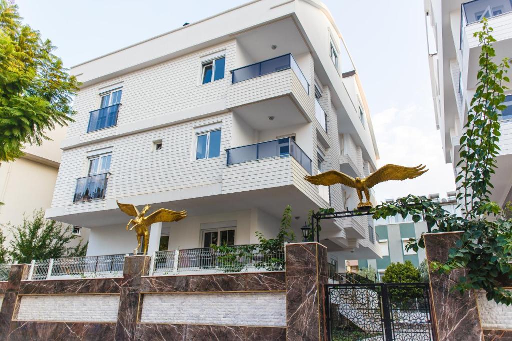 un edificio blanco con estatuas delante en Family Apart-Hotel "2022"- 3, en Antalya