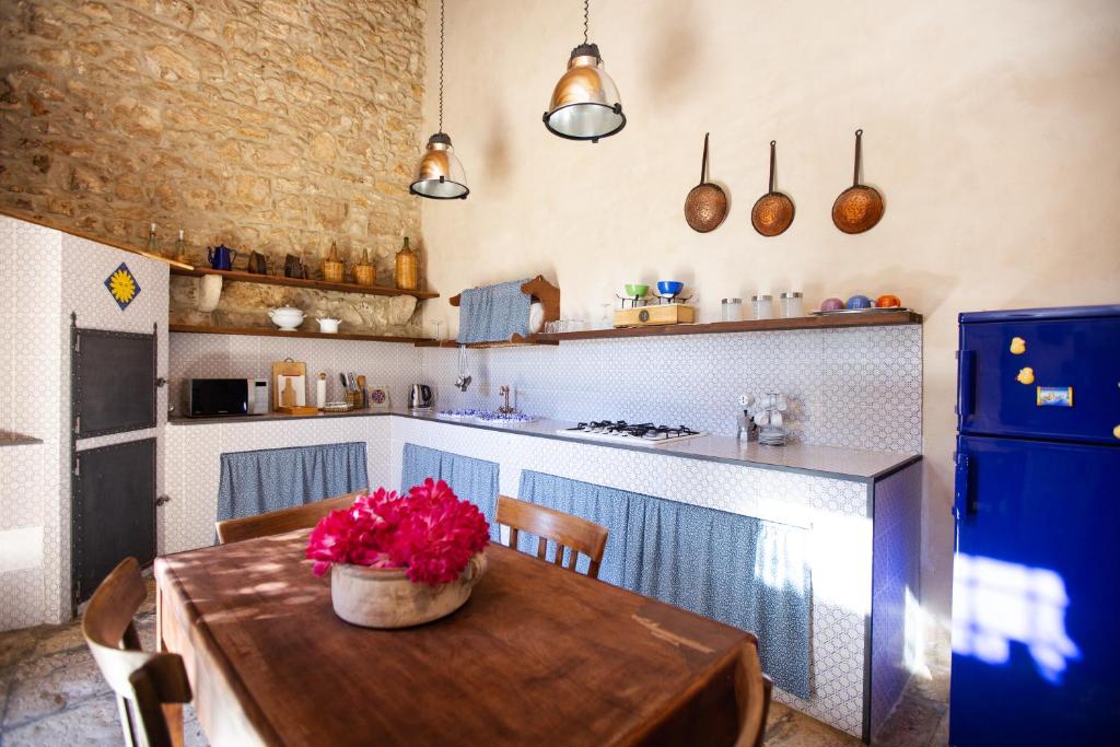 una cocina con una mesa de madera con un tazón de flores. en IzzHome Country, en Santa Croce Camerina