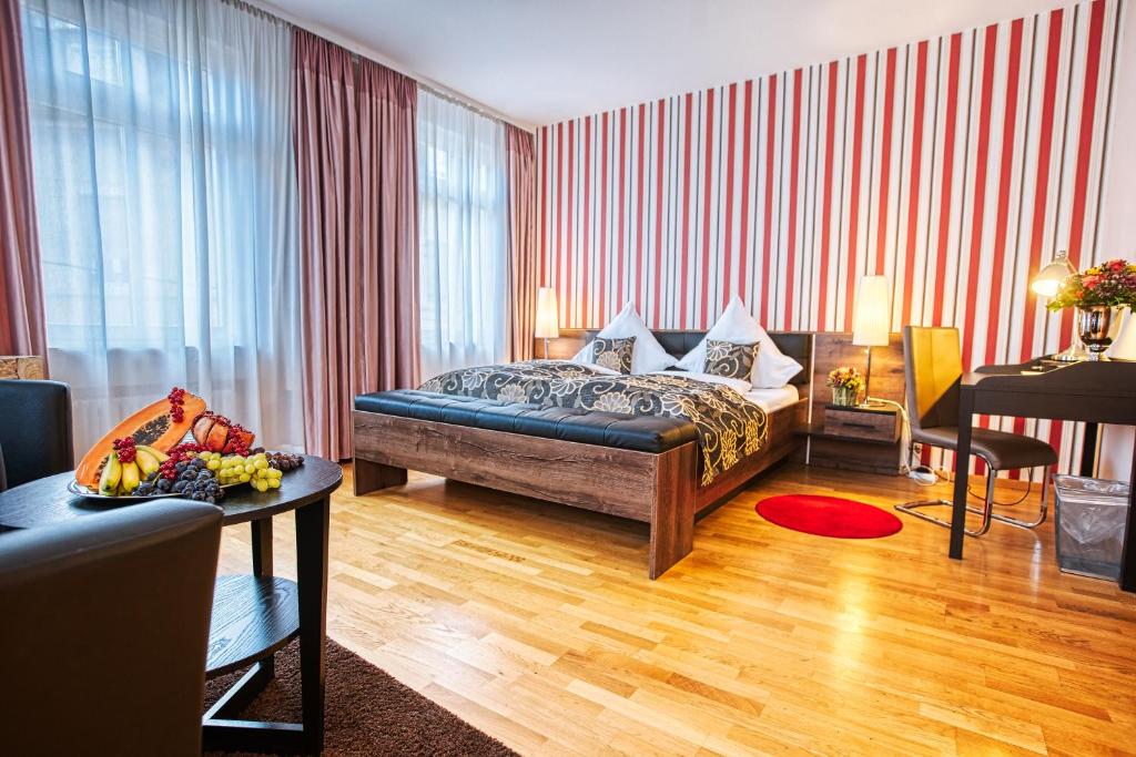 sypialnia z łóżkiem i stołem w pokoju w obiekcie Suiten Hotel Dependance Laterne w Baden-Baden
