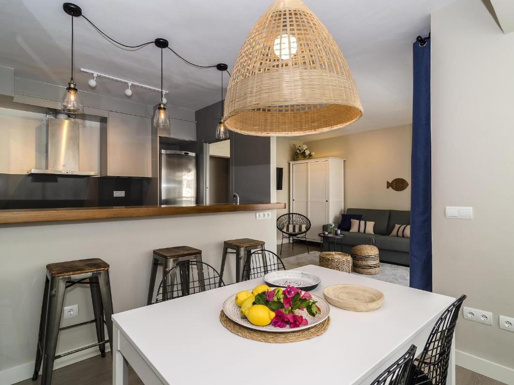 a kitchen with a table with a bowl of fruit on it at Sitges Spaces Deluxe Centre Apartment in Sitges