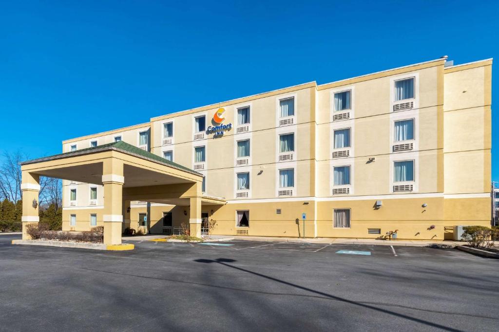 un grand bâtiment avec un parking en face de celui-ci dans l'établissement Comfort Inn Mechanicsburg - Harrisburg South, à Mechanicsburg