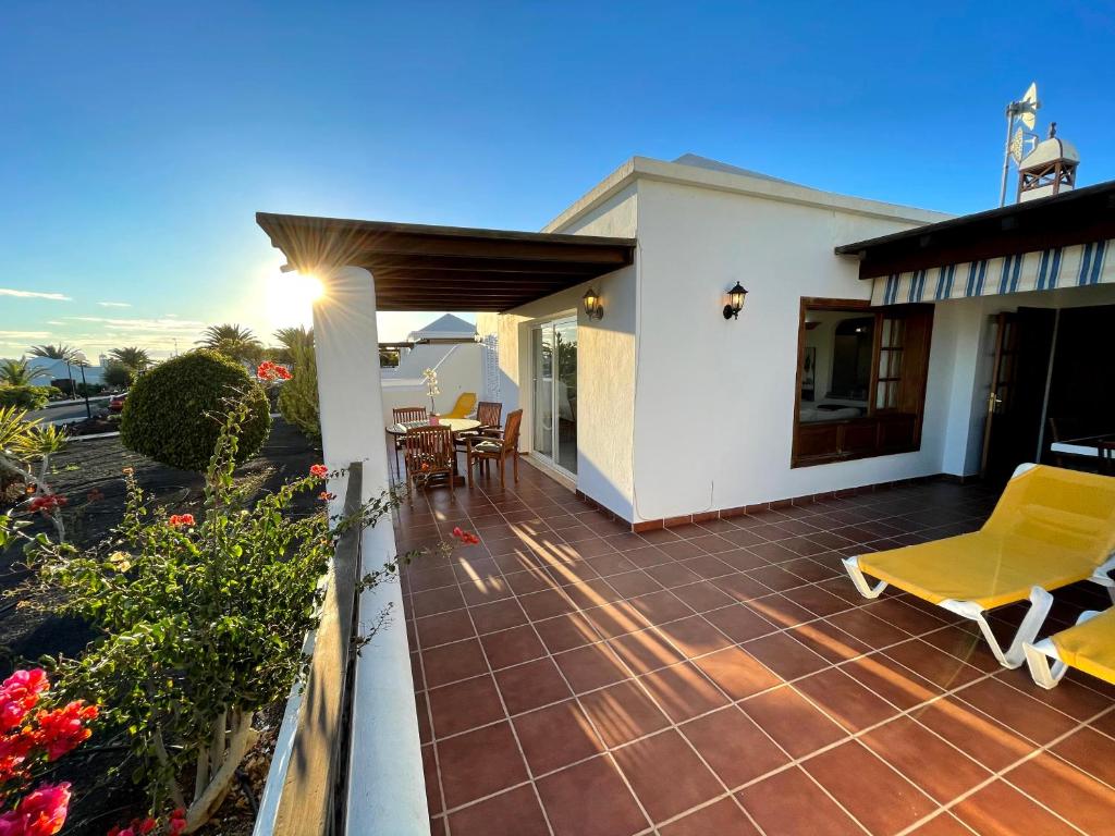een patio met gele stoelen en een huis bij Carlos Park 51 in Playa Blanca