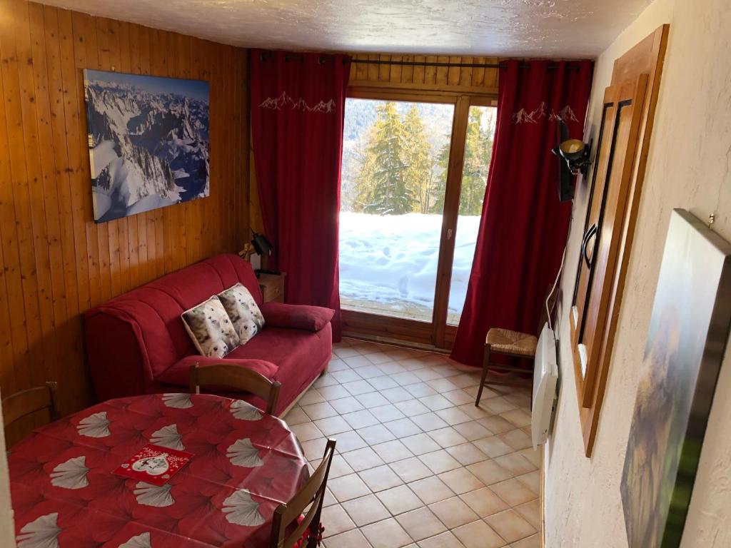 a living room with a red couch and a table at Petite Marmotte in Saint-Gervais-les-Bains