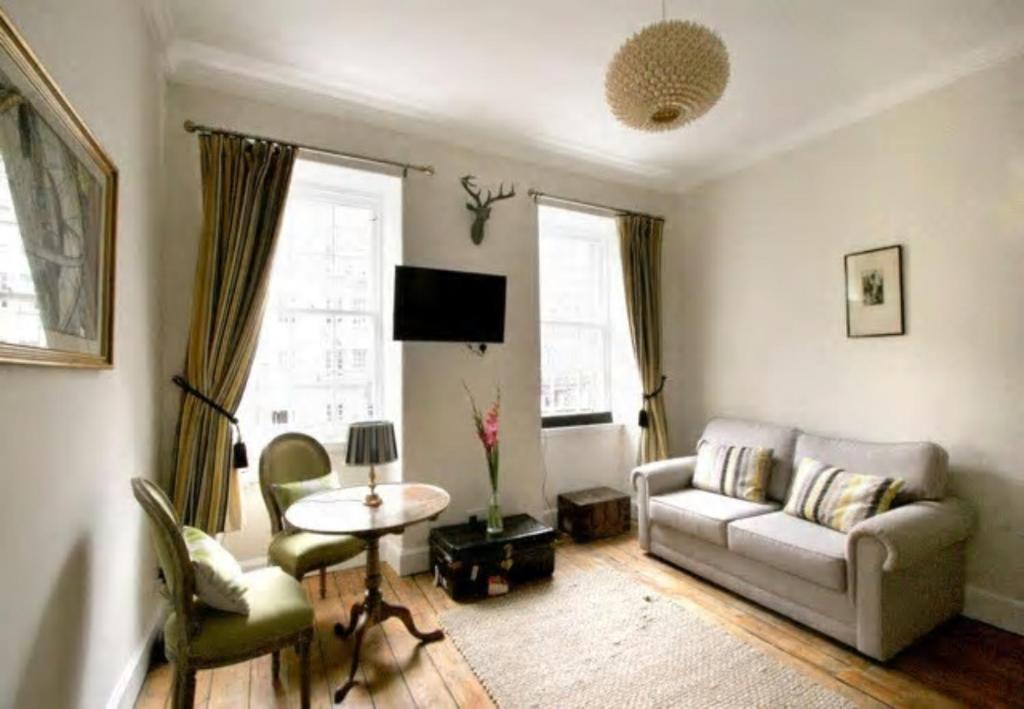 een woonkamer met een bank en een tafel bij ALTIDO Chic apt in the Royal Mile Tower in Edinburgh