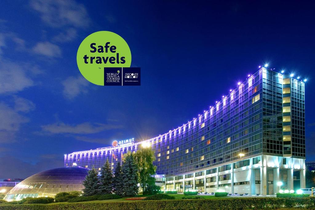 un gran edificio con un cartel que lee viajes seguros en AZIMUT Hotel Olympic Moscow, en Moscú