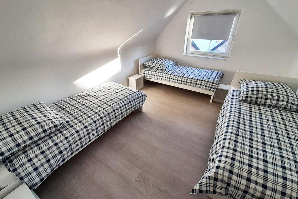 um pequeno quarto com 2 camas e uma janela em Work & Stay Apartments mit Garten 
