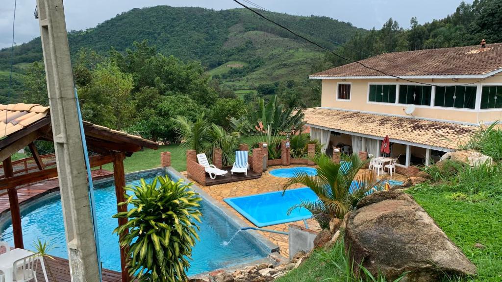 une villa avec une piscine et une maison dans l'établissement Sítio Maranata Vale das Montanhas, à Monte Alegre do Sul