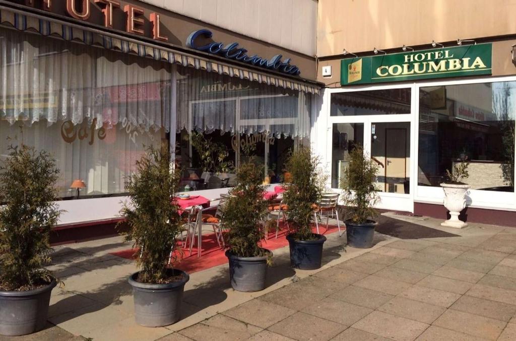 a row of potted trees in front of a store at Hotel Columbia in Berlin