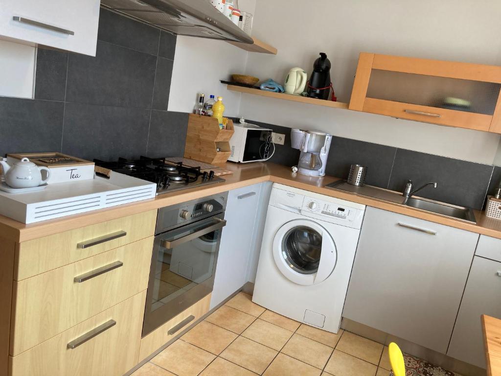 a kitchen with a washing machine and a washer at L'escale Granvillaise in Granville