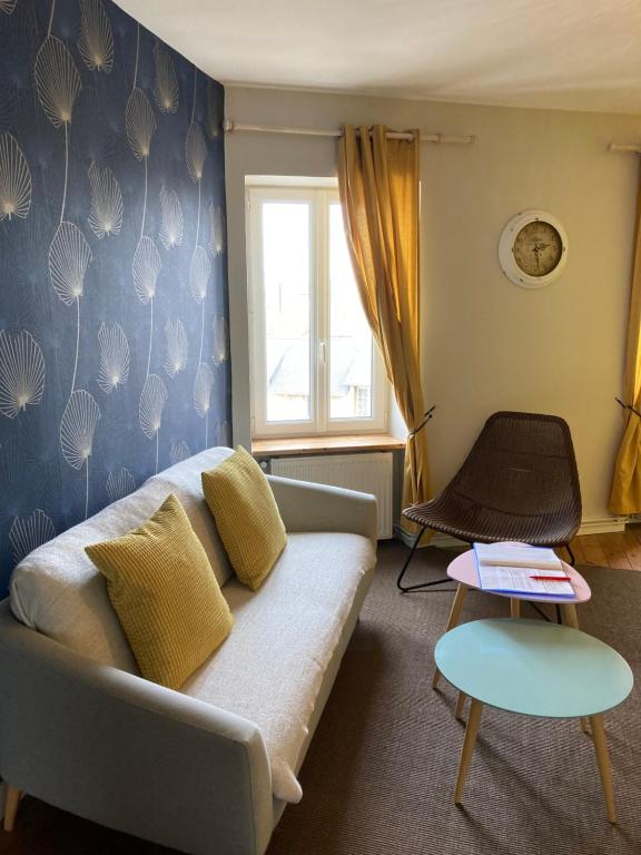 a living room with a couch and a window at L'escale Granvillaise in Granville