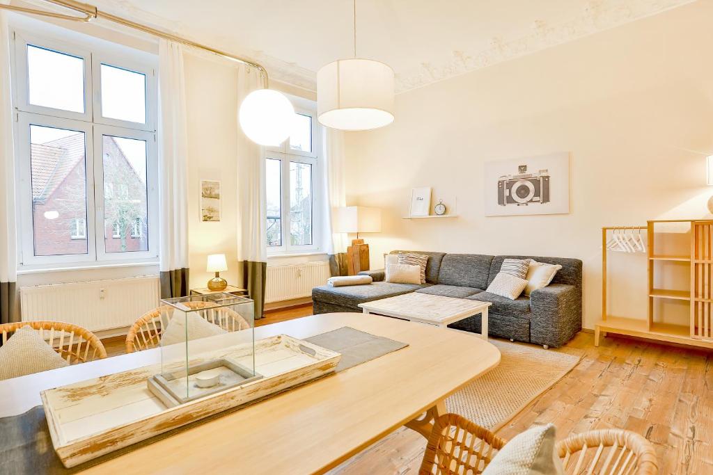 uma sala de estar com uma mesa e um sofá em Apartmenthaus Tribseer Damm 6 em Stralsund