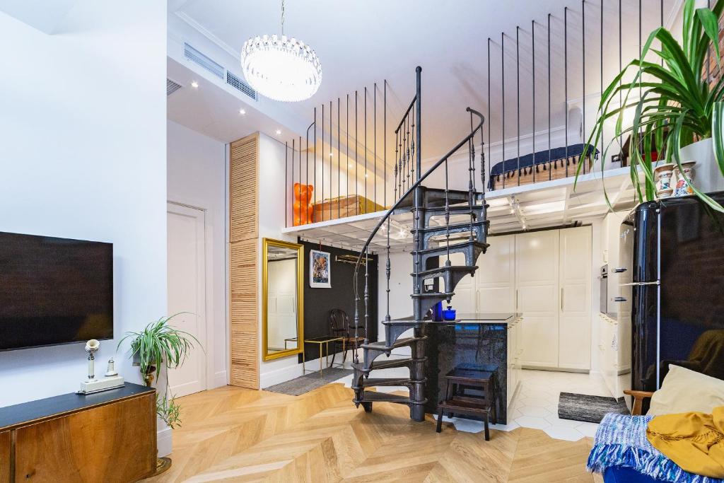 a living room with a spiral staircase and a tv at Retro Apartment Old Town in Wrocław